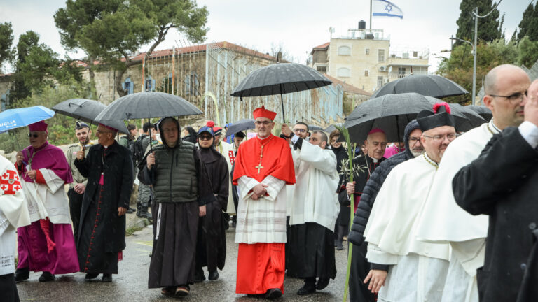 Kardinal Pierbattista Pizzaballa (m.), Lateinischer Patriarch von Jerusalem, während der Palmsonntagsprozession mit Regen auf dem Ölberg am 13. April 2025 in Jerusalem (Israel).