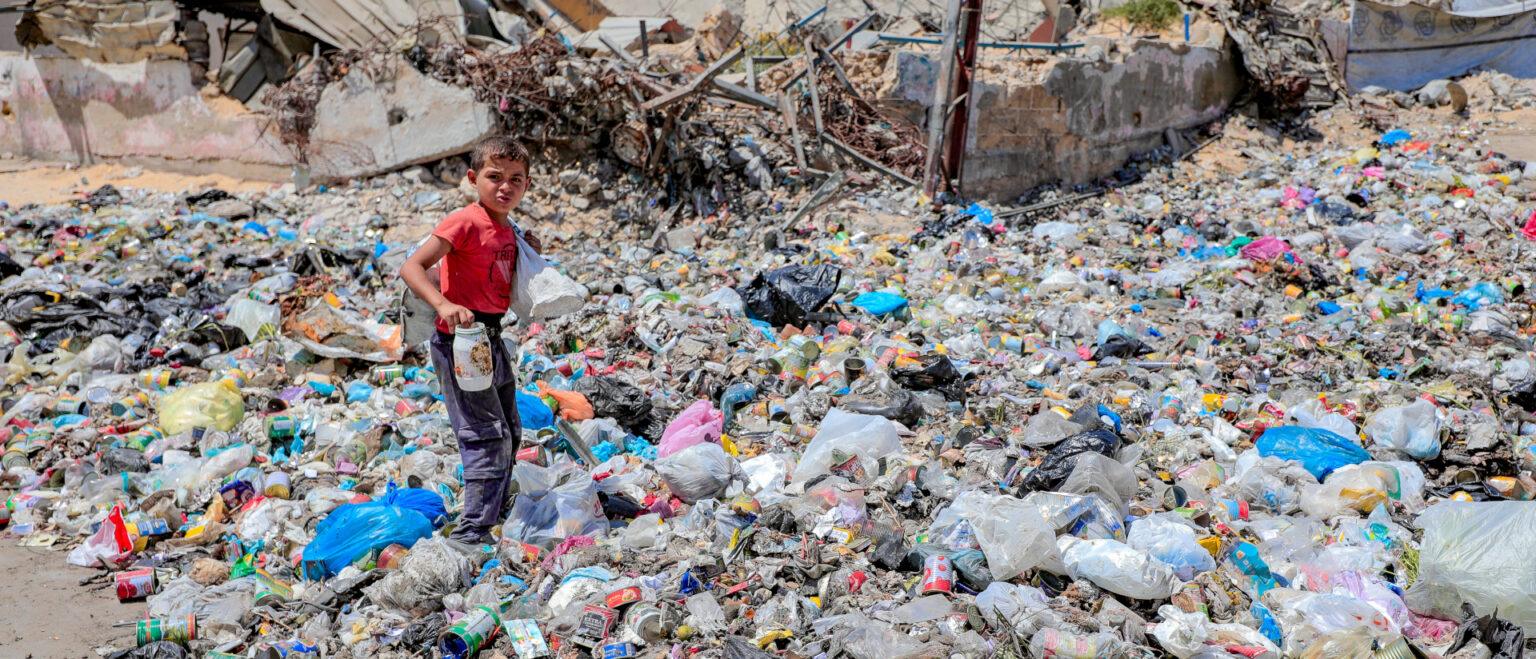 Ein Kind sucht im Müll nach Essbarem am 27. August 2025 auf einer Strasse in Gaza. | Mohammed Ibrahim/KNA