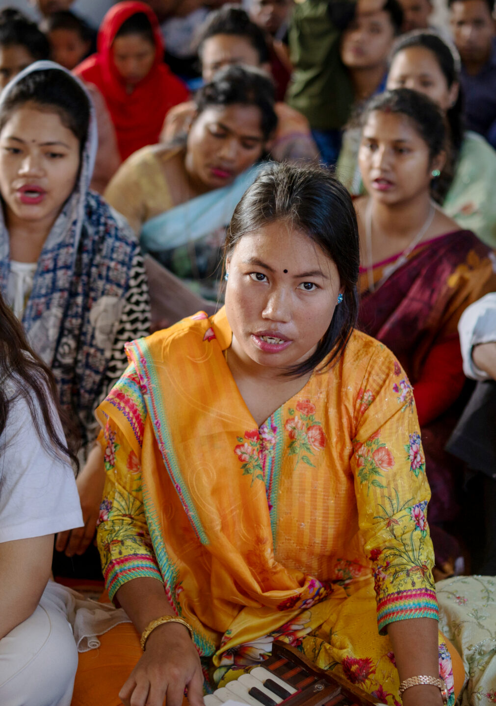 Chorsängerin bei einem Gottesdienst in Bangladesch, im Hintergrund Gläubige.