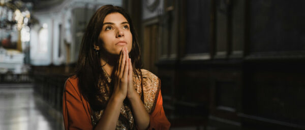 Eine Frau betet in einer Kirche. | Pexels