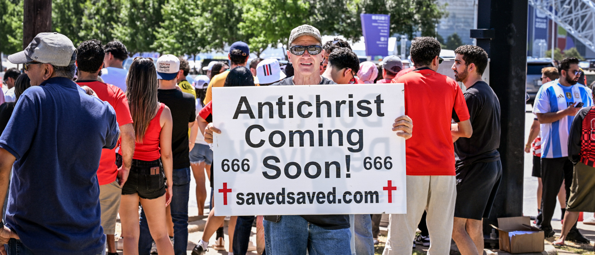 Ein Mann hält ein Plakat mit der christlichen Botschaft "Antichrist coming soon!" (dt. der Antichrist kommt bald!), am 3. Juli 2026 am Rande eines Spiels der Fussball-Weltmeisterschaft 2026 in Dallas (USA).