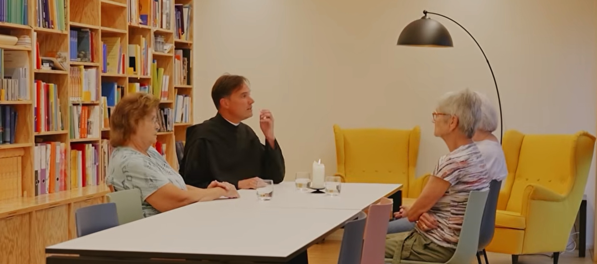 Pater Aaron Brunner arbeitet für die Pfarrei Einsiedeln, hier im Gespräch mit drei Frauen. | Youtube/Kloster Einsiedeln