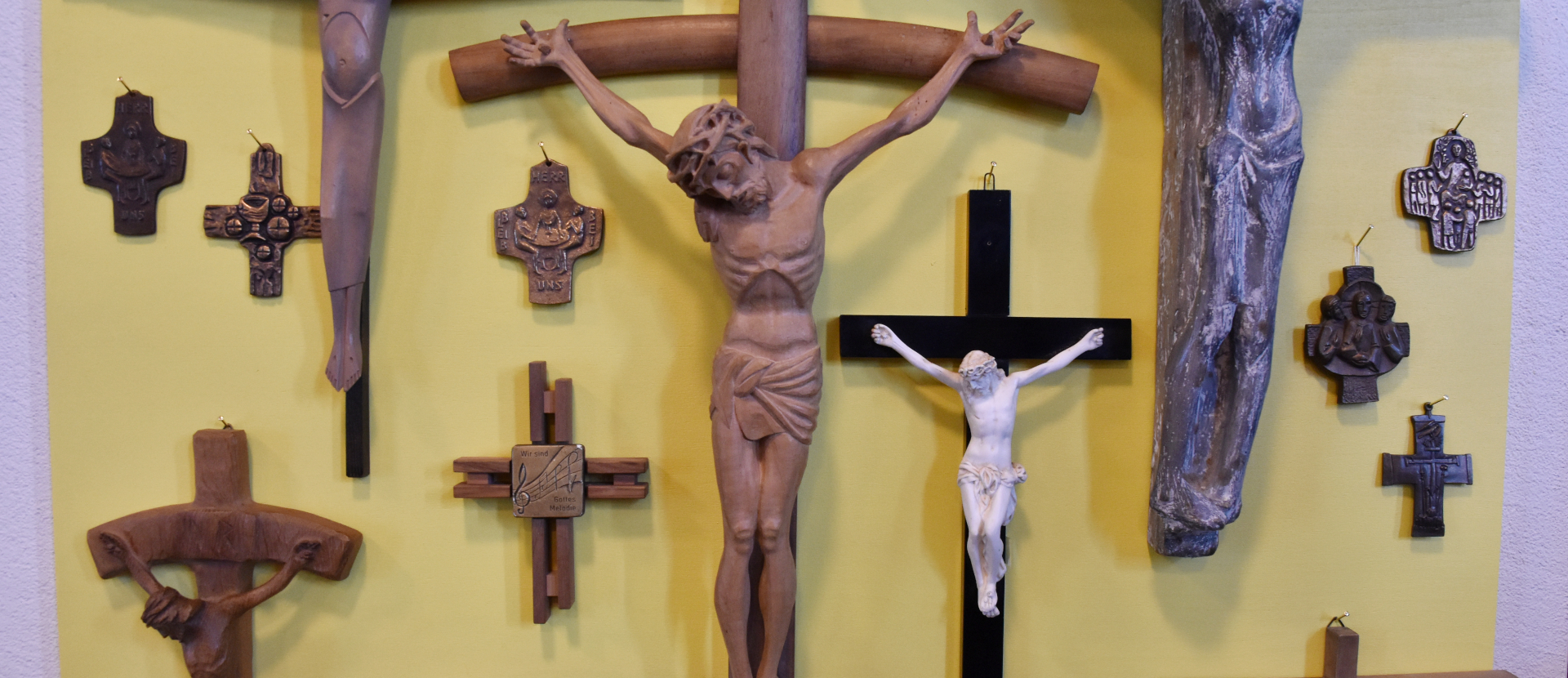 Hauskreuze hängen an einer gelbbemalten Wand in der Pfarrkirche Maria Himmelfahrt in Jona SG, 12. September 2026.